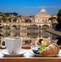 Saint Peter`s Basilica and Tiber river against cup of fresh coffee with croissant in Rome, Italy Royalty Free Stock Photo