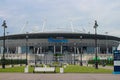 An alley with benches and lanterns in front of the modern stadium Gazprom Arena against