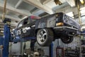 Black custom Volga GAZ-24 on a car lift on a service station