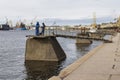 Mooring bulls with fishermen near the embankment of the Neva River