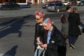 Two young fashionable girls walk along a street in the center of the city