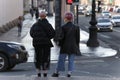 Two young fashionable girls walk along a street in the center of the city