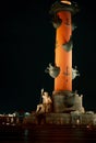 Rostral columns. Ancient Roman statue and column close-up on the background of the night city.