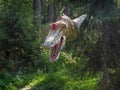 Predatory dinosaur suddenly appeared from the dark thicket of the forest. Animation sculpture dinosaur