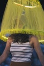 Girl under the translucent yellow lampshade with night illumination