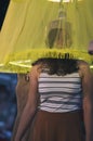 Girl under the translucent yellow lampshade with night illumination