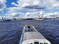 Boats and yachts with tourists sail to the Neva to see warships and sailboats for the Day of