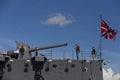 Close up side view of the forecastle bow of moored Cruiser Aurora . People taking photos with the gun and naval jack flag Royalty Free Stock Photo