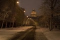 Saint Petersburg, Russia in darkness of winter early morning. St. Isaac Cathedral, an empty snowy street and bare trees Royalty Free Stock Photo