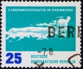 Saint Petersburg, Russia - December 19, 2019: Postage stamp issued in the German Democratic Republic depicting a butterfly swimmer