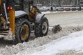 Tractor clears the road of snow on a gloomy winter day Royalty Free Stock Photo