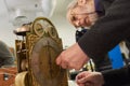 Watch restoration workshop of the state hermitage. Restorer at work repairs gears, watchmaker tools on the table