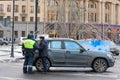 Traffic police inspector checks documents of stopped driver on roadside in Saint Petersburg, Russia