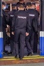 A group of policemen gets into an underground subway car