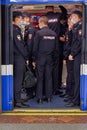 A group of policemen gets into an underground subway car