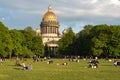 Lawn on Senate Square with people resting in front of St. Isaac`s Cathedral. Saint Petersburg, Russia