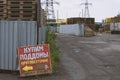 Rows of pallets behind the fence and posters with the inscription in Russian