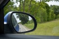 Rural lanscape country road is reflected in side mirror of car during the summer trip perspective from automobile Royalty Free Stock Photo