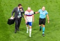 Russia national team doctor Eduard Bezuglov and Spanish referee Antonio Mateu Lahoz escoring injured mifielder Daler Kuzyaev out