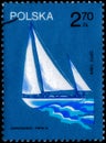 Saint Petersburg, Russia - March 06, 2020: Postage stamp issued in the Poland with the image of the Sailboat Opty, sailed around