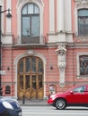 Saint-Petersburg, RUSSIA Ã¢â¬â May 1, 2019: Facade of old building on Nevsky Avenue with cars riding along, Saint-Petersburg.