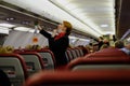 Stewardess in a mask demonstrates to aircraft passengers the rules of conduct in an abnormal emergency and instructs on safety