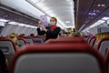 Stewardess in a mask demonstrates to aircraft passengers the rules of conduct in an abnormal emergency and instructs on safety