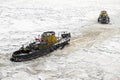 Saint Petersburg, Russia - 28.18.2022 two small vintage icebreaker ships make their way through the frozen icy sea Royalty Free Stock Photo