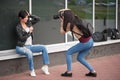 Young woman photographer doing a photoshoot with model outdoors