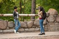 Young woman photographer doing a photoshoot with model outdoors