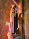 Saint therese of lisieux statue, with magnificent stained glass reflections Royalty Free Stock Photo