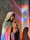 Saint therese of lisieux statue, with magnificent stained glass reflections Royalty Free Stock Photo