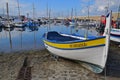 Saint Tropez Wooden Boat with clear water reflection and brick wall that leads to the lighthouse