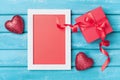 Saint valentine day greeting card. Frame, gift box and red heart on turquoise wooden background top view. Royalty Free Stock Photo