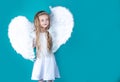 Saint Valentines Day card. Child wearing long white dress and angel wings. Happy angel girl over white. Beautiful young Royalty Free Stock Photo