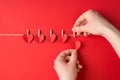 Saint valentines day is almost here concept. Close up view photo image of girl hand putting last paper heart on a peg isolated Royalty Free Stock Photo