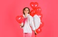 Saint Valentines day. Sexy angel woman with red heart balloons. Female cupid in white angelic wings.