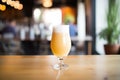 saison beer in a glass with a frothy head