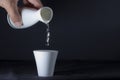 Sake pouring from a bottle into a cup of white for celebration. Royalty Free Stock Photo