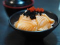 Sake Salmon Rice Japanese Style Chirashi scattered topping with Tobiko Flying fish roe in black bowl Royalty Free Stock Photo