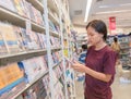 Sakon Nakhon, Thailand-August 5, 2023: Unidentified happy young woman woman shopping and choosing books in the bookstore