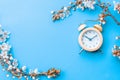 Sakura background with flower blossom and April floral nature with alarm clock on blue. Beautiful scene with blooming Royalty Free Stock Photo