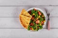 Salad with arugula, pineapple and strawberries on a white plate with pita bread Royalty Free Stock Photo