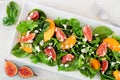 Salad of arugula, spinach, figs and cheese in a white rectangular plate, overhead on marble Royalty Free Stock Photo