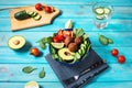 Salad with avocado, falafel, cucumber, cherry tomato and spinach on blue wooden background. Healthy vegan lunch Royalty Free Stock Photo