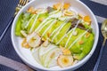 Salad with avocado serving on white plate