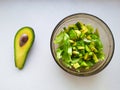 Salad with avocado and sesame seeds, oil is poured, on a wooden. Avocado salad in a plate, vegetarian food, green dietary salad Royalty Free Stock Photo