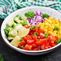 Salad with avocado, tomatoes, red onions and sweet corn in bowl. Royalty Free Stock Photo