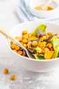 Salad with baked pumpkin and chickpeas with mustard-honey dressing in a white plate, macro. Healthy vegan food concept. Royalty Free Stock Photo