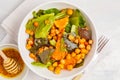 Salad with baked pumpkin and chickpeas with mustard-honey dressing in a white plate, top view. Healthy vegan food concept. Royalty Free Stock Photo